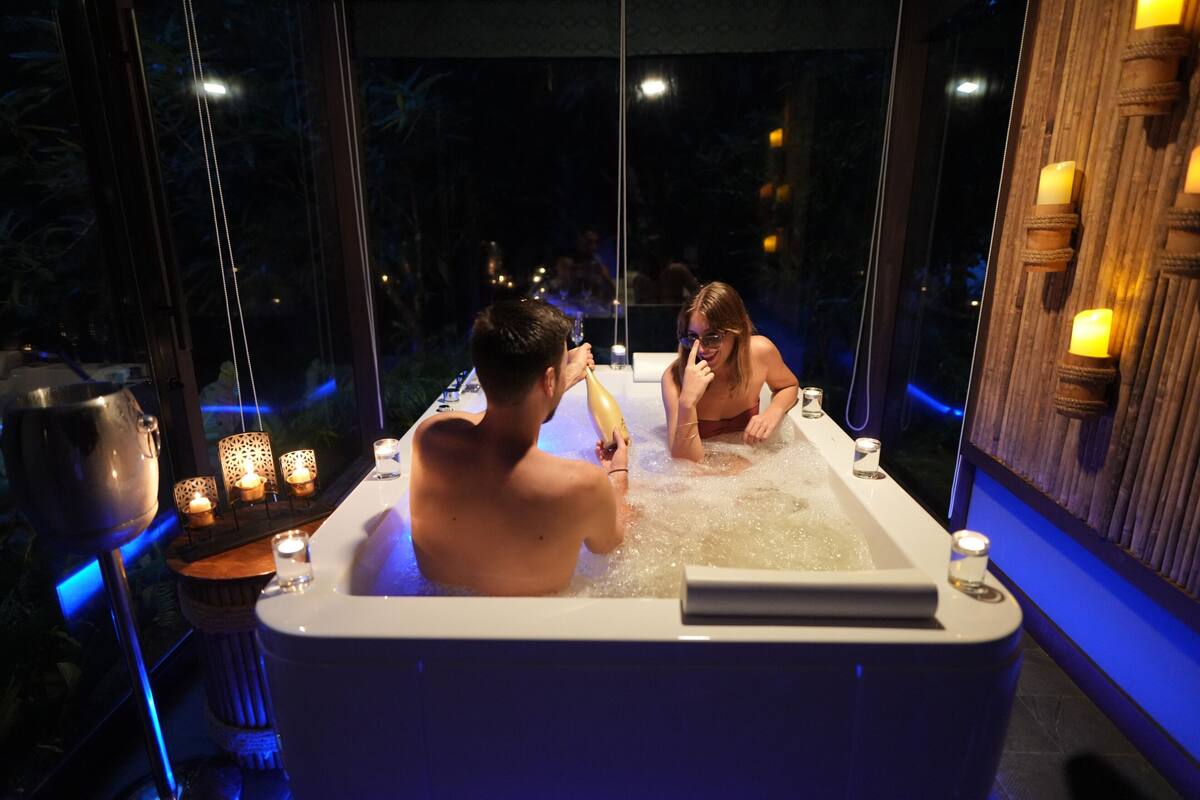 A couple in a hot tub with a view of the night sky.