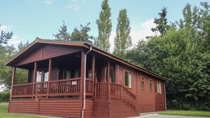 Uma cabana de madeira com varanda e escada que leva à entrada.