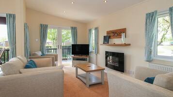 A living room with two sofas, a TV, a fireplace, and a dining table.