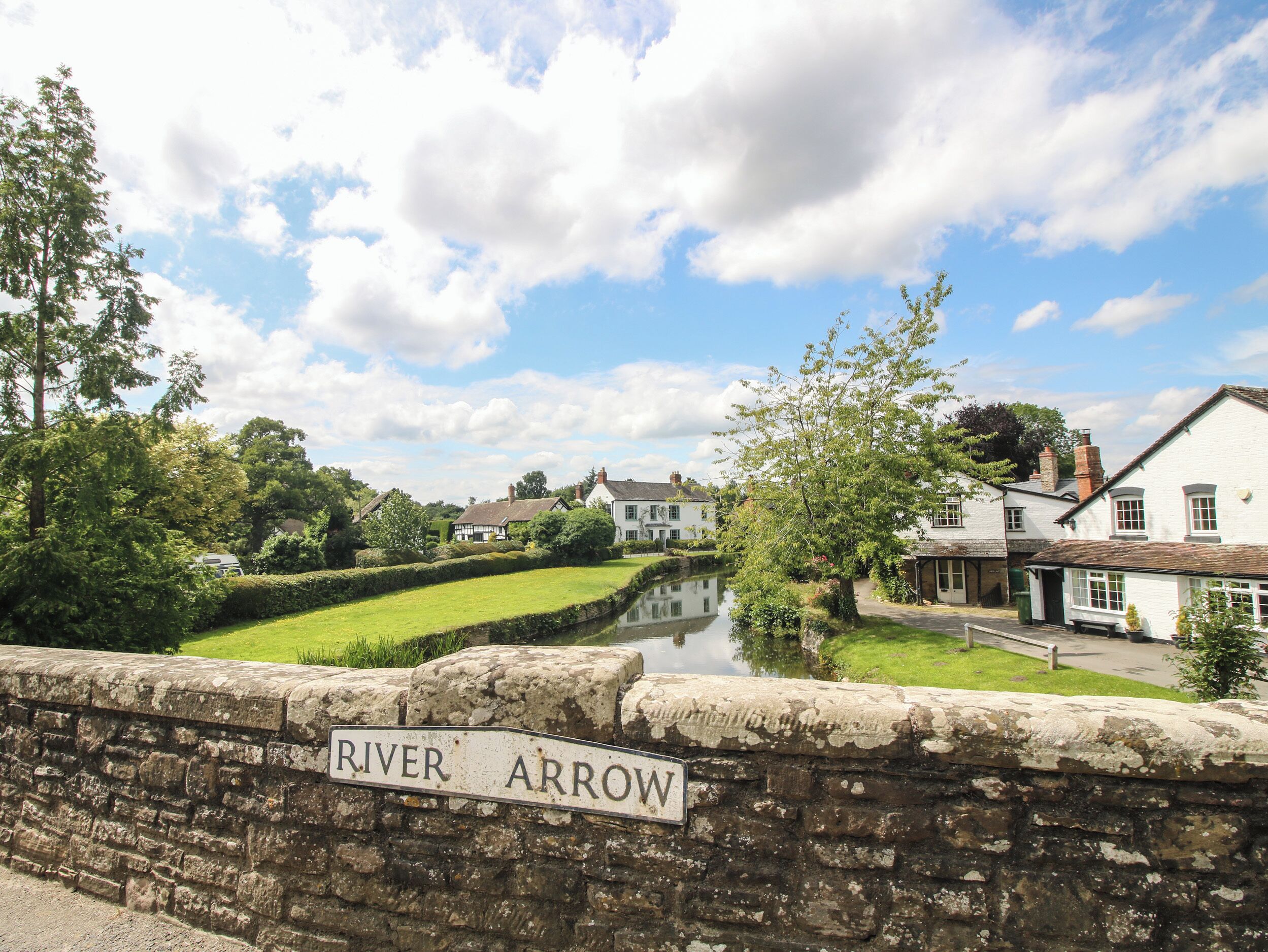 A stone bridge with a sign reading "River Arrow."