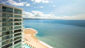 A high-rise hotel with a beach view, multiple balconies, and a pool area. - Stunning Beach Front Condo in Peninsula Tower 1! 3BD Condo for rent in North Hot (Puerto Vallarta)