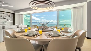 A modern dining area with a round table, white chairs, and a view of the ocean. - Stunning Beach Front Condo in Peninsula Tower 1! 3BD Condo for rent in North Hot (Puerto Vallarta)