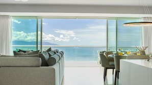 A modern living room with a large sofa, dining area, and a view of the ocean. - Stunning Beach Front Condo in Peninsula Tower 1! 3BD Condo for rent in North Hot (Puerto Vallarta)