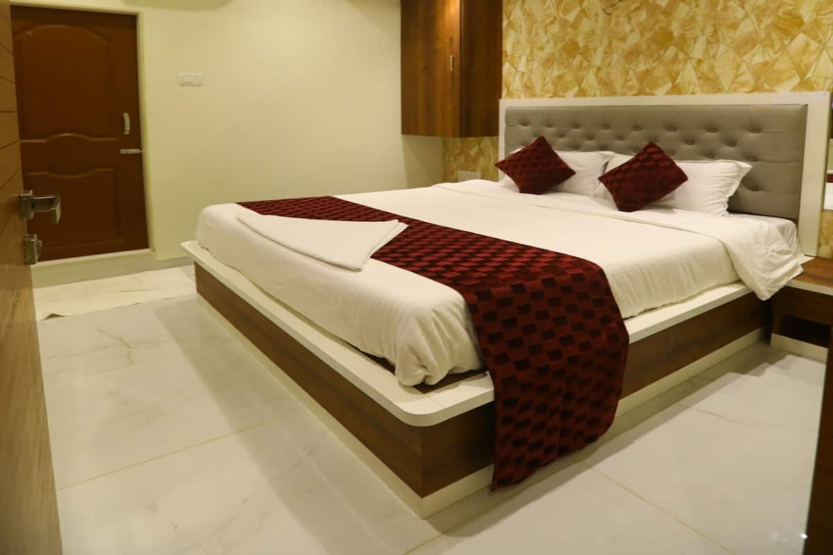 A modern bedroom with a large bed, a ceiling fan, and a patterned wall.