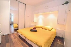 Une chambre à coucher avec un lit, une table de chevet et une armoire.