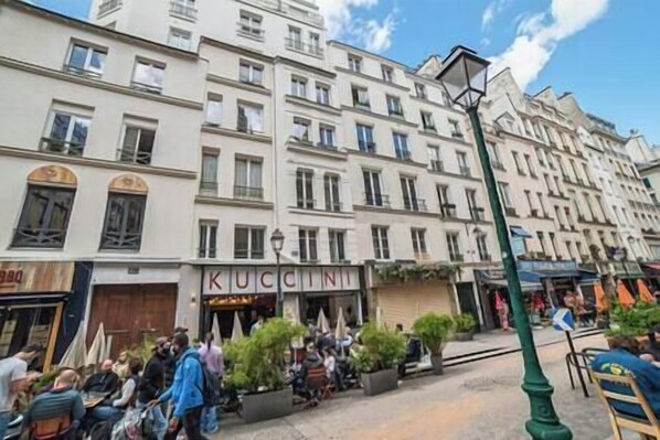 A street scene with a building labeled "KUCCINI" and outdoor seating.