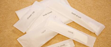Various toiletry items including a shower cap, body towel, toothbrush, razor, comb, and cotton swab.