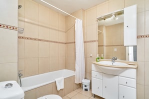 A bathroom with a bathtub, toilet, sink, and mirror. - Apartment "Carabeo 23" with Sea Views and Direct Beach Access (Nerja)