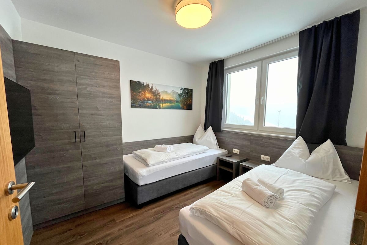 Ein Hotelzimmer mit einem Bett, einem Schreibtisch, einem Kleiderschrank und einem Bild an der Wand.