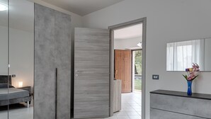 Une chambre à coucher moderne avec une porte coulissante, un lit, une commode et un miroir.