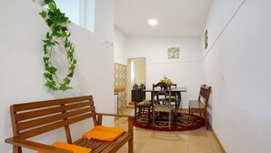 A room with a wooden bench, a dining table with chairs, and a patterned rug. - Holiday Home "Casal Do Farrobo" with Sea View, Private Terrace & Wi-Fi (Funchal)