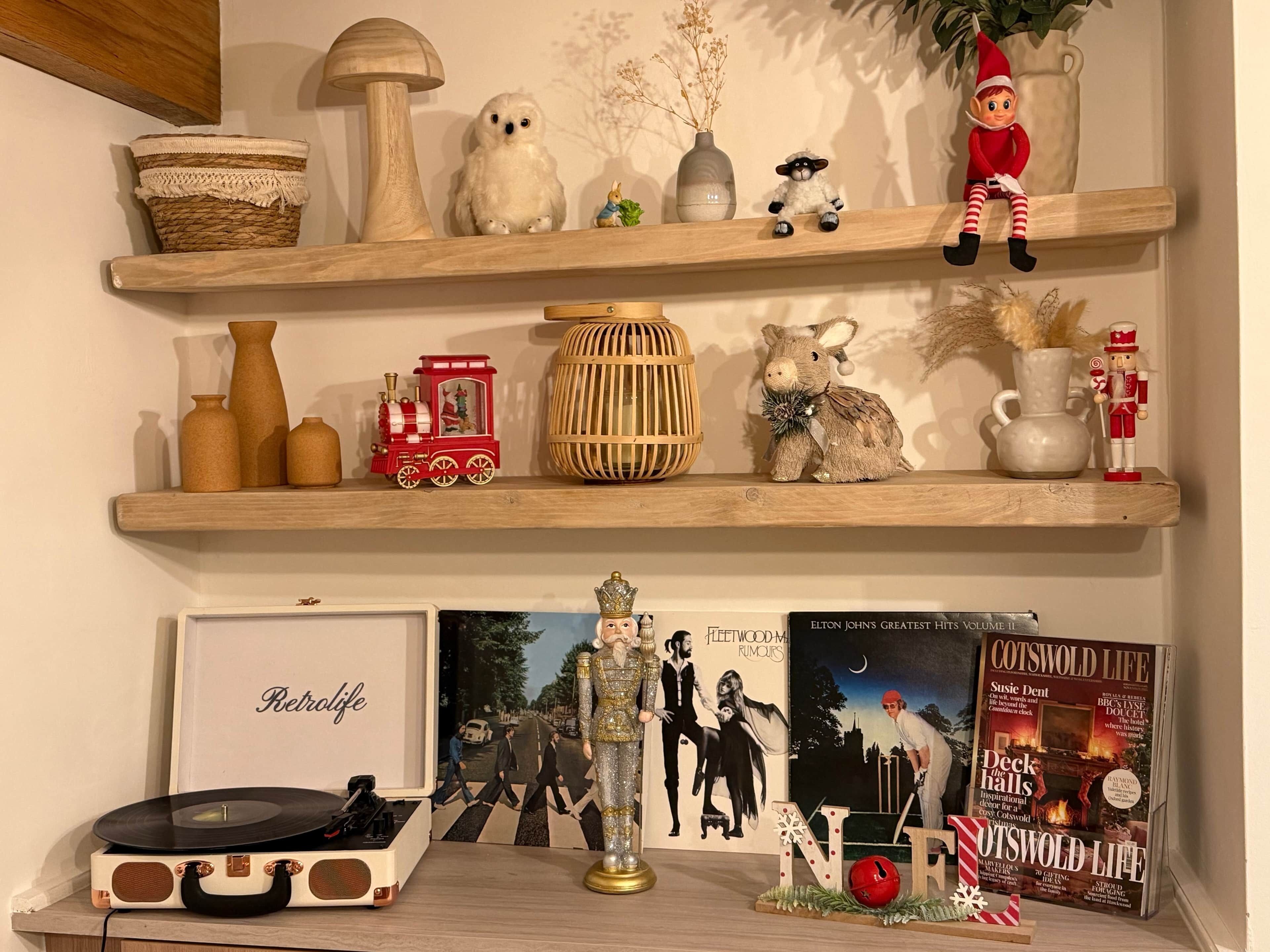 A shelf with various decorative items including a small train, a book titled "Retrodlife," and a vinyl record player.