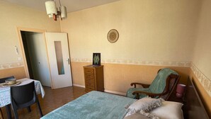 Une chambre à coucher comprenant un lit, une chaise, une commode et une petite table.