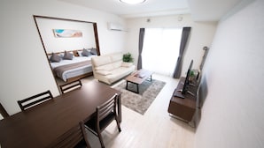 Una sala de estar moderna con un sofá, una mesa de comedor y un televisor.