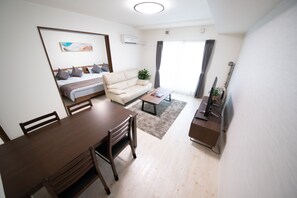 A modern living room with a sofa, a dining table, and a TV. - OTARU SAMPO (Otaru)