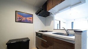 Una cocina moderna con horno empotrado, pileta y muebles de madera.
