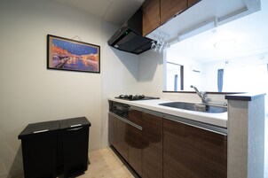A modern kitchen with a built-in oven, a sink, and wooden cabinets.