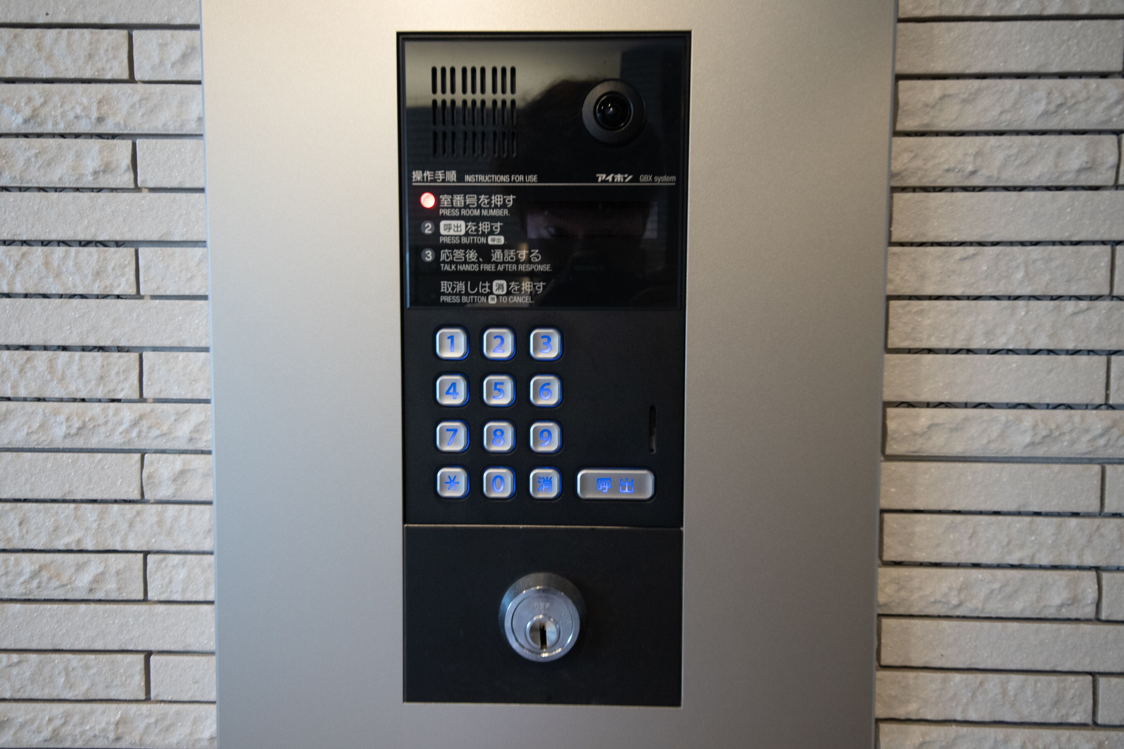 A keypad entry system with instructions in multiple languages, a camera, and a lock mechanism.