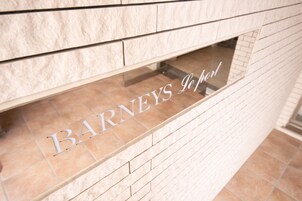 A sign with the name "Barneys" on a building facade.