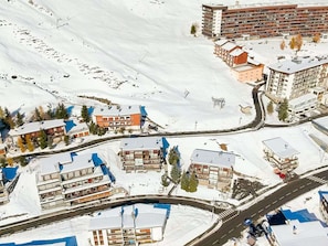 A snow-covered town with buildings, roads, and a ski lift.