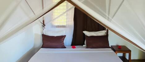 A bed with a canopy, pillows, and a decorative towel.