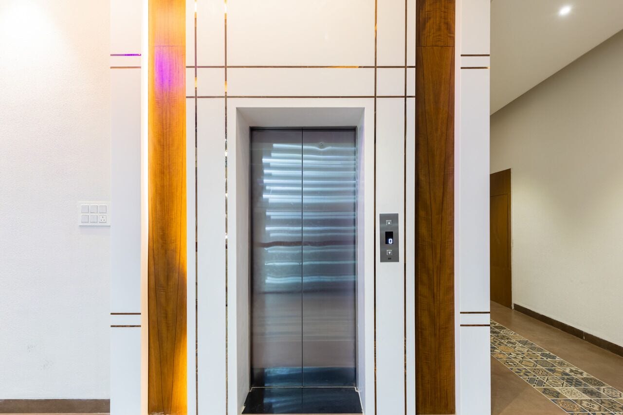 A modern elevator with a sleek design, featuring a metallic finish and horizontal lines on the doors.