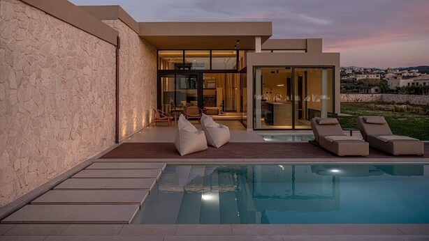 A modern house with a swimming pool, outdoor seating, and a view of the surrounding landscape. - Pnoe Seafront Experience | Villa Alas (Kolymvari)