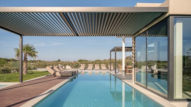 Area piscina esterna moderna con vista aperta sul paesaggio, una pergola e sedie a sdraio.