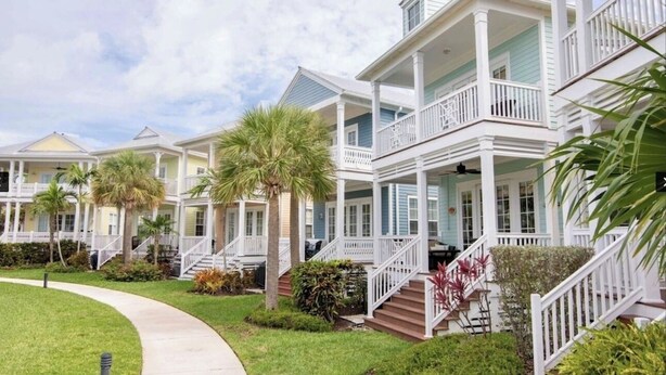 A row of coastal-style houses with front porches and steps leading to the entrance. - Beautiful Waterfront Villa 133 Anglers Reef with On-Site Boat Slip  (Islamorada)