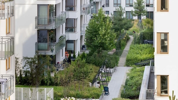 A modern apartment building with balconies, a green rooftop garden, and a pedestrian pathway. - Stylish Apartment in Wrzeszcz | Balcony | For 4 People (Gdansk)