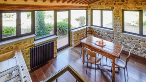 A kitchen with a stone wall, wooden ceiling, and large windows. - Gorgeous home in Bibbiena (Bibbiena)
