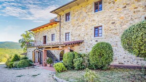 A stone building with a balcony, a staircase, and a well-maintained garden. - Gorgeous home in Bibbiena (Bibbiena)