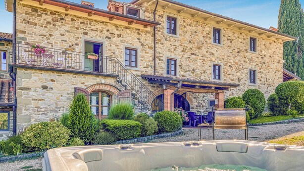 A stone building with a balcony, a hot tub, and well-maintained gardens. - Gorgeous home in Bibbiena (Bibbiena)