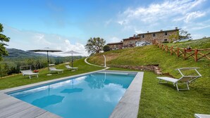 A swimming pool with lounge chairs, a stone building, and a view of the hills. - Gorgeous home in Bibbiena (Bibbiena)