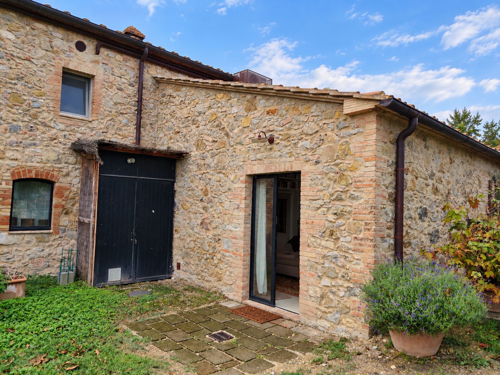 A stone building with a black door and a window.