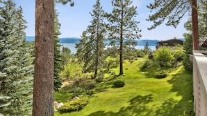 A lush garden with a view of a lake and mountains in the background. - Luxury Mountain retreat with Hot tub (Zephyr Cove)