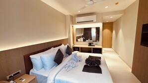 Una habitación de hotel con cama, mesita de noche y escritorio con espejo.