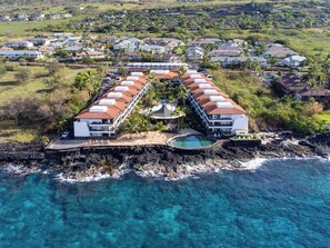 Un complexe hôtelier comprenant un long bâtiment, une piscine et une côte rocheuse.