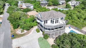 A residential area with a prominent house featuring a large balcony and a pool. - Make Way For Ducklings - Wild Duck Dunes, Ocean Views, 160 Yds to Beach, Saltwater Pool, Flex Stays (Duck)