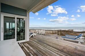 A wooden deck with outdoor furniture, a glass door leading to a balcony, and a view of the ocean. - Topsail's Treasure #148 - Oceanfront Home w/ Community Pool & Sound Access! (North Topsail Beach)