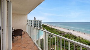 Een balkon met uitzicht op een strand en de oceaan.