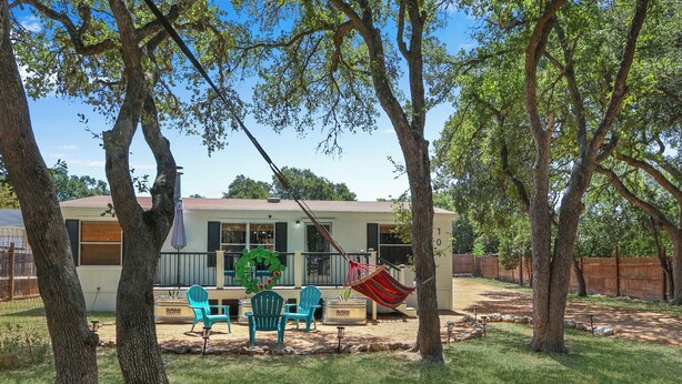 A house with a patio area, outdoor furniture, and a hammock.