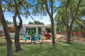 A house with a patio area, outdoor furniture, and a hammock. - Howdy Hideaway I River Park, Three miles to Wimberley Square (Wimberley)