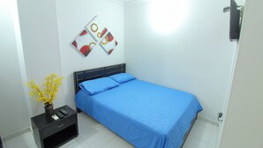 A small, neatly arranged bedroom with a single bed, a nightstand, a wall-mounted TV, and a decorative wall piece. - 1 Bedroom Studio Apartment in Rodadero (Santa Marta)