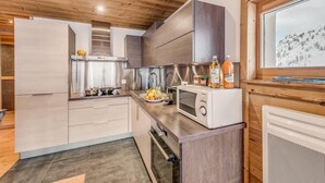 Una cocina moderna con armarios de madera, microondas y ventana con vista nevada.