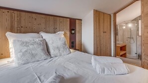 A bedroom with a wooden headboard, a large bed with white linens, and a wooden wardrobe. - 1st floor, swimming pool, sauna, balcony, fireplace or stove, parking, tv, ski locker, 83m² (Champagny-en-Vanoise)