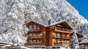 A wooden chalet with multiple balconies, surrounded by snow-covered trees and mountains. - 1st floor, swimming pool, sauna, balcony, fireplace or stove, parking, tv, ski locker, 71m² (Champagny-en-Vanoise)