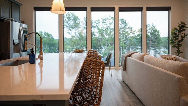 A modern kitchen with a central island, large windows, and a sofa in the living area. - A Stoney Marina - Lake Arrowhead (Waleska)