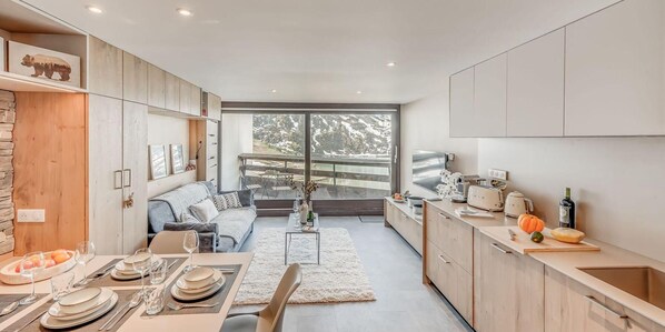 Relax in a spacious living area with a sofa and dining table for four, and enjoy a view of the surrounding landscape from the kitchen window.