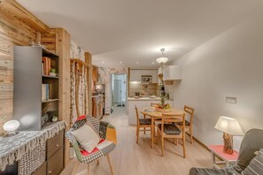 A modern living room with a dining area, wooden decor, and a kitchen in the background. - 300m from resort center, 4th floor, balcony, tv, ski locker, 39m², Tignes (Tignes)